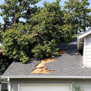 Tree damage requiring roof repair after storm causes major roof damage